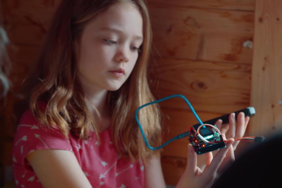 Young girl looking at a homemade electronic device.