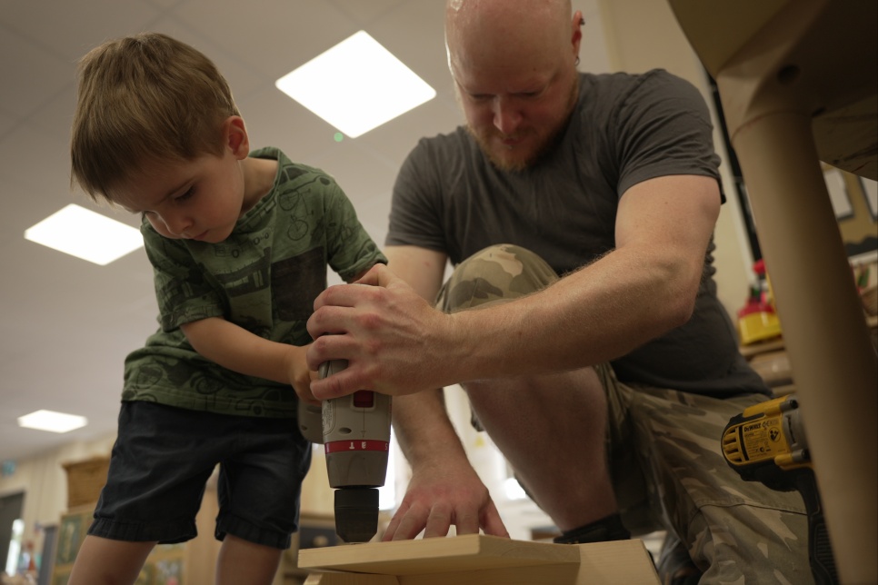  Creative Practitioner, Ellwyn Male drilling a piece of wood with a pupil from Cylch Meithrin Llanhari  